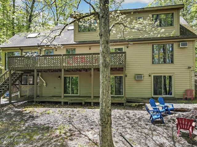 146 Cove Point Cir, Lakeville, PA 18438 - back of property with a fire pit, a wooden deck, stairway, and a shingled roof