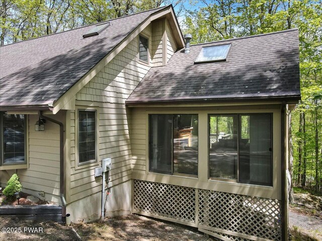 146 Cove Point Cir, Lakeville, PA 18438 - back of house featuring a shingled roof and a sunroom