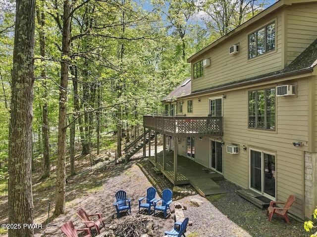 146 Cove Point Cir, Lakeville, PA 18438 - back of property with a fire pit, a deck, stairway, and an AC wall unit