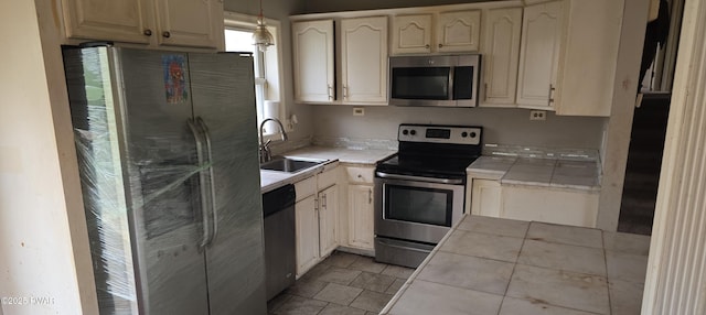 171 Flatbrook Way, Milford, PA 18337 - kitchen with stainless steel appliances, decorative light fixtures, tile countertops, and a sink