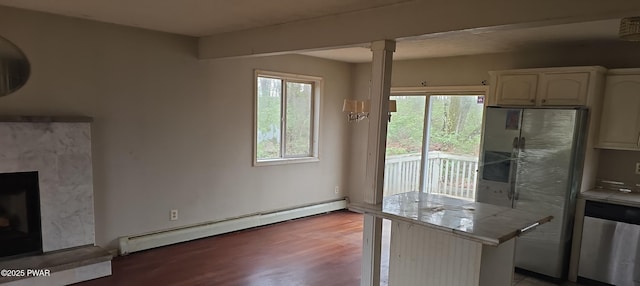 171 Flatbrook Way, Milford, PA 18337 - kitchen featuring a fireplace with raised hearth, baseboard heating, appliances with stainless steel finishes, wood finished floors, and tile counters