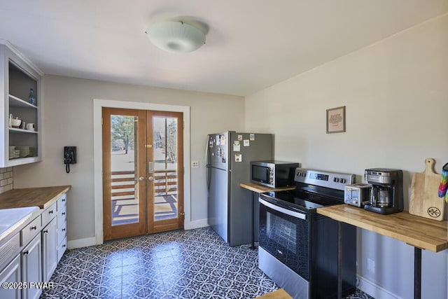 kitchen with stainless steel appliances, baseboards, butcher block counters, and french doors