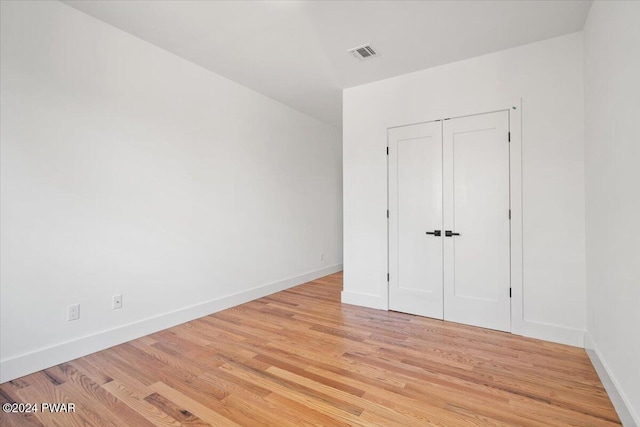 unfurnished bedroom featuring light hardwood / wood-style floors and a closet