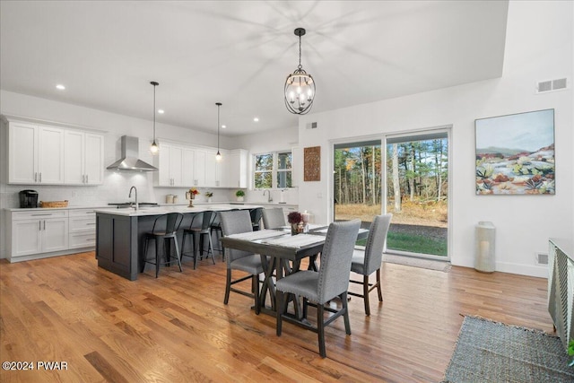 dining space featuring a chandelier, light hardwood / wood-style floors, and sink