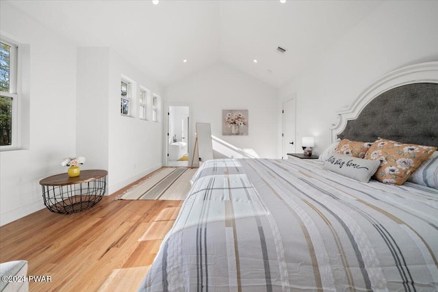 bedroom with hardwood / wood-style floors and lofted ceiling