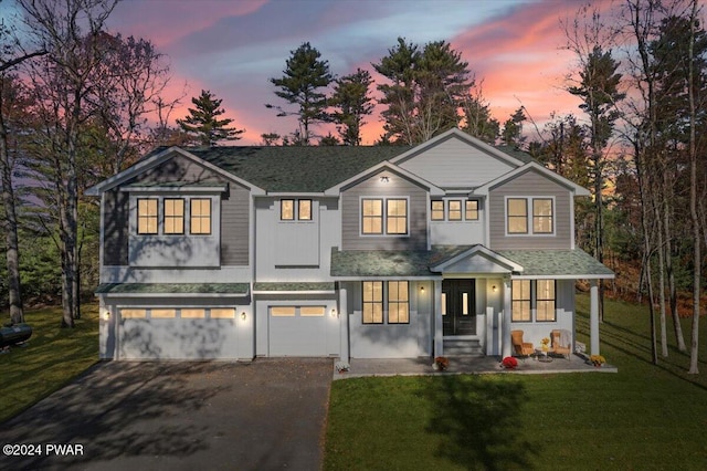 view of front facade with a yard and a garage