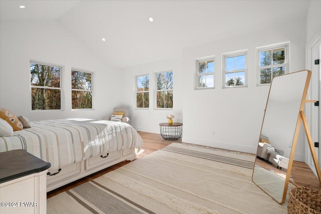 bedroom featuring light wood-type flooring and vaulted ceiling