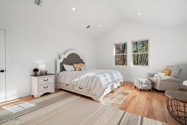 bedroom featuring light hardwood / wood-style floors and vaulted ceiling