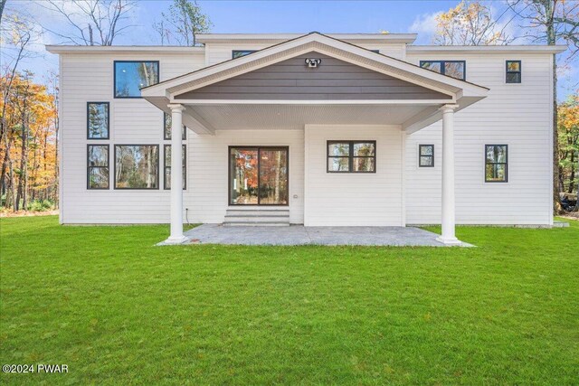 rear view of property featuring a lawn