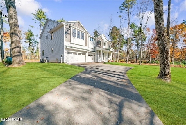 view of front facade featuring a garage, a front lawn, and central air condition unit