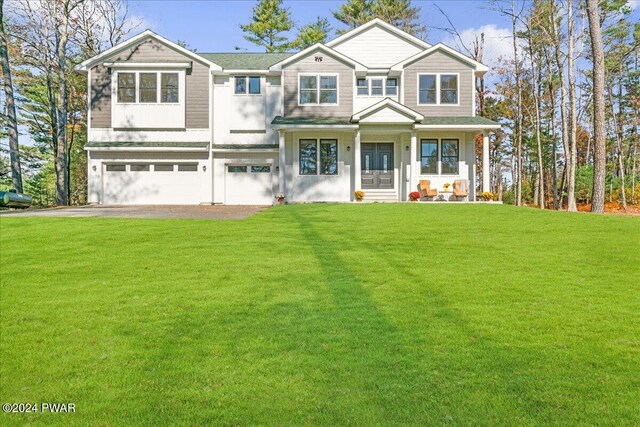 view of front of property with a front yard, a garage, and covered porch