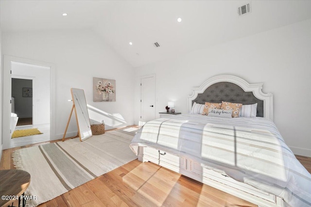 bedroom with hardwood / wood-style flooring and high vaulted ceiling