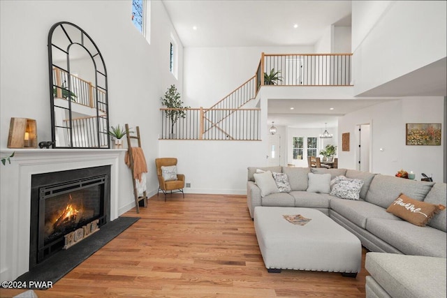 living room with a high ceiling and light hardwood / wood-style floors