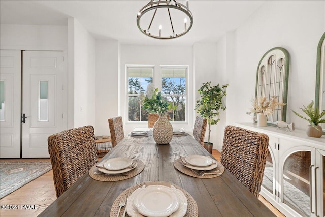 dining space featuring light hardwood / wood-style flooring and a notable chandelier