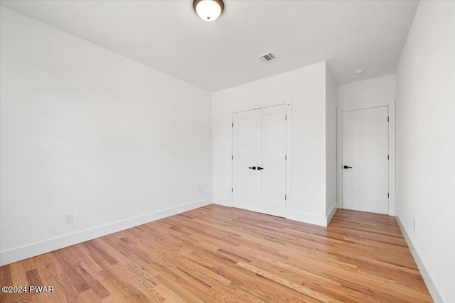 unfurnished bedroom with light hardwood / wood-style floors and a closet