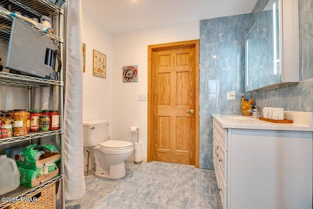 bathroom featuring vanity, toilet, and tile walls