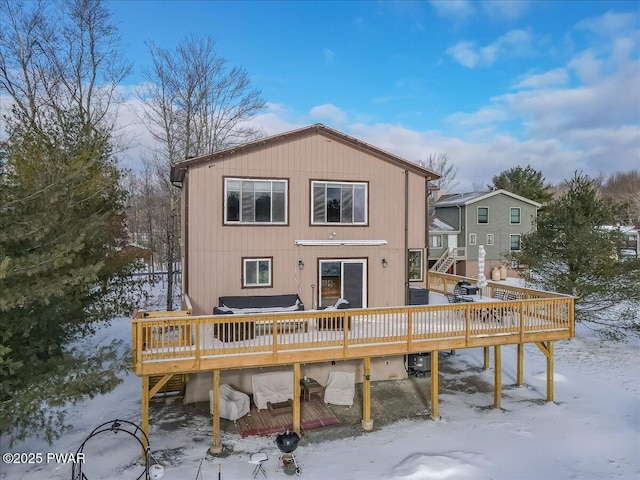 snow covered rear of property featuring a wooden deck