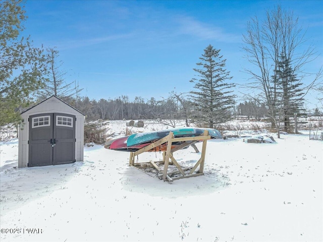 yard covered in snow featuring a shed