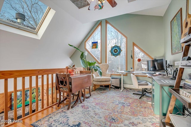 office with ceiling fan, vaulted ceiling with skylight, and light wood-type flooring