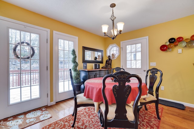 dining room featuring light wood-type flooring and an inviting chandelier