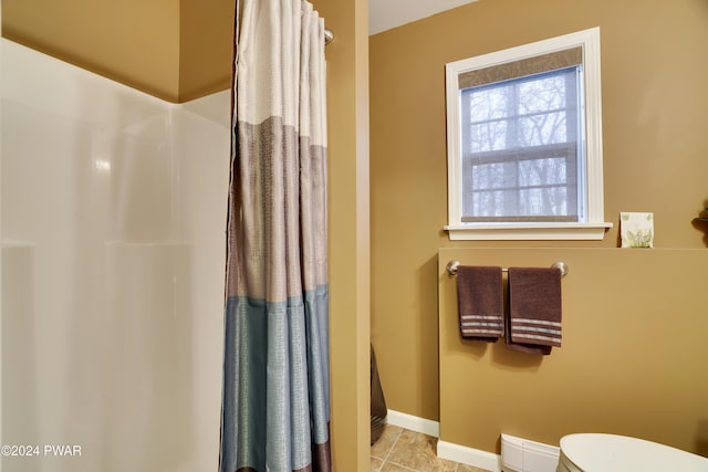 bathroom featuring a shower with curtain and toilet