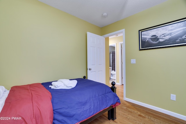 bedroom featuring wood-type flooring and a textured ceiling