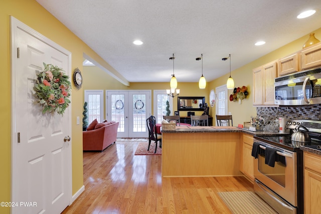 kitchen with kitchen peninsula, light brown cabinets, stainless steel appliances, and french doors