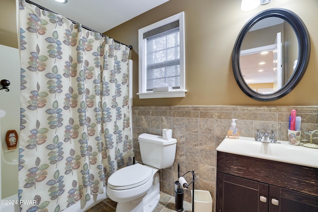 bathroom featuring a shower with shower curtain, vanity, toilet, and tile walls