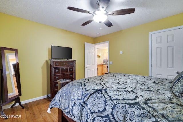 bedroom featuring hardwood / wood-style floors, ceiling fan, a textured ceiling, and a closet