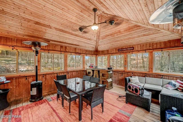 sunroom featuring lofted ceiling, wooden ceiling, and a ceiling fan