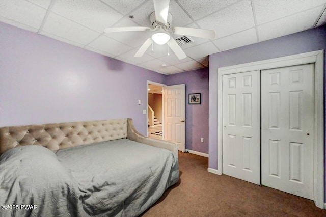 bedroom featuring a paneled ceiling, baseboards, visible vents, and carpet