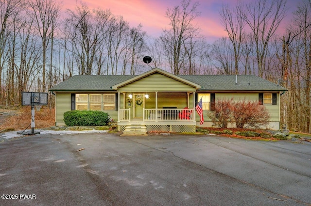 single story home featuring covered porch and roof with shingles