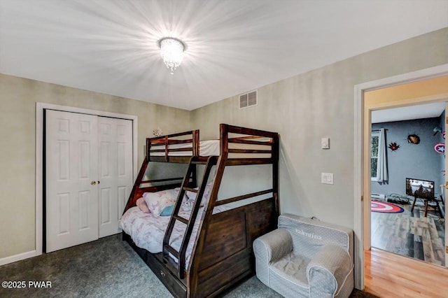 bedroom with visible vents, a closet, and wood finished floors