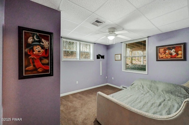 carpeted bedroom with a paneled ceiling, a ceiling fan, visible vents, and baseboards