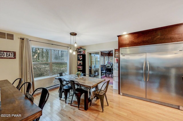 dining room featuring light wood finished floors and visible vents