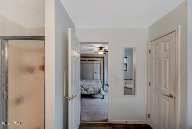 hall featuring dark colored carpet and baseboards