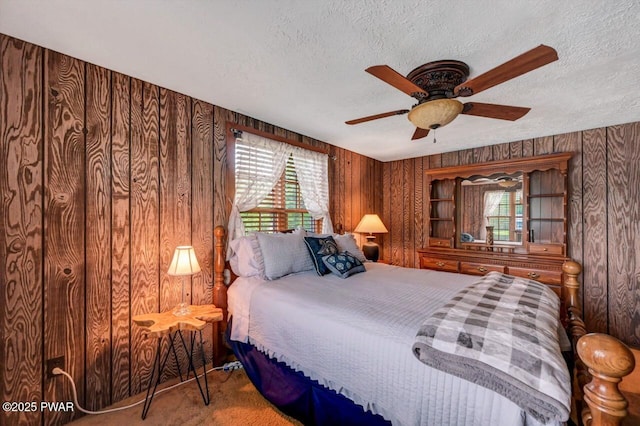 29 Tanglewood Ln, Lake Ariel, PA 18436 - carpeted bedroom featuring a textured ceiling, multiple windows, wood walls, and a ceiling fan