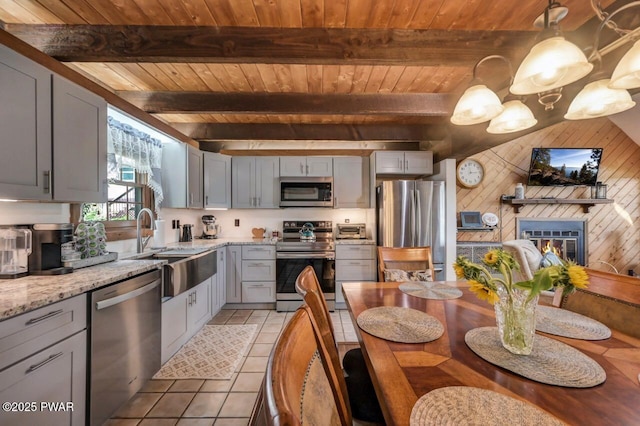 29 Tanglewood Ln, Lake Ariel, PA 18436 - kitchen with appliances with stainless steel finishes, a wood ceiling with exposed beams, light tile patterned floors, gray cabinets, and wooden walls