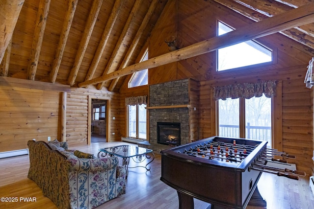 recreation room featuring beamed ceiling, light wood-type flooring, wood ceiling, and a fireplace