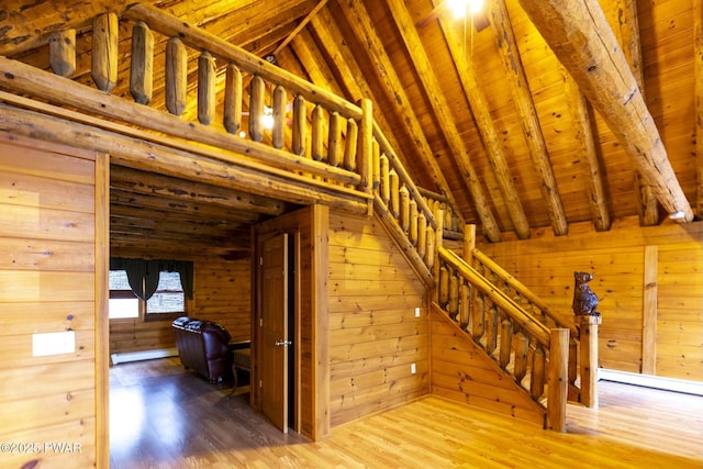 stairs featuring wood ceiling, hardwood / wood-style flooring, a baseboard radiator, vaulted ceiling with beams, and wood walls