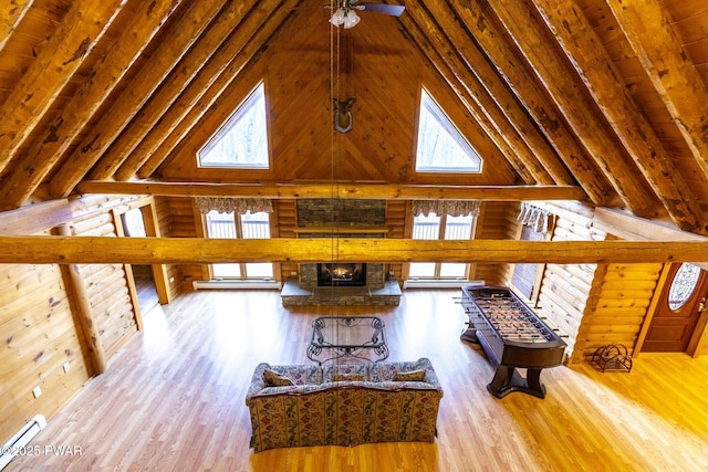 unfurnished living room featuring ceiling fan, light hardwood / wood-style flooring, high vaulted ceiling, and a healthy amount of sunlight