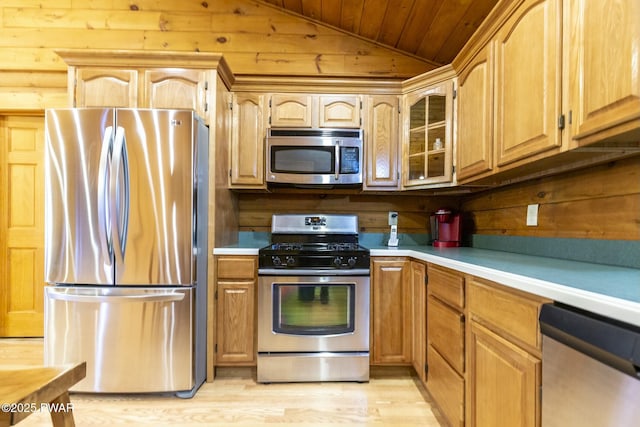 kitchen featuring wooden ceiling, wood walls, lofted ceiling, appliances with stainless steel finishes, and light wood-type flooring