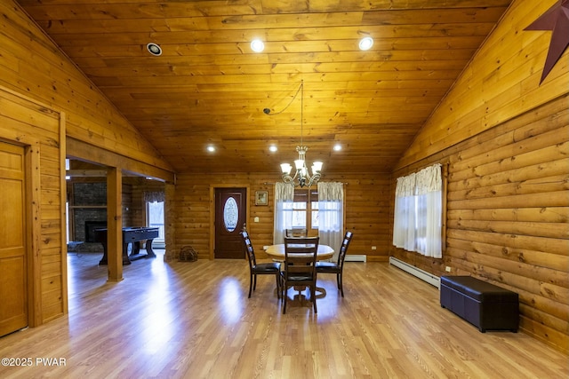 dining room featuring baseboard heating, rustic walls, a fireplace, and lofted ceiling