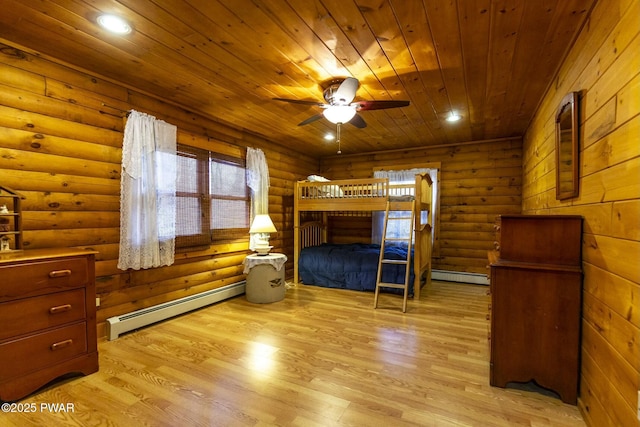 bedroom featuring light hardwood / wood-style floors, rustic walls, ceiling fan, and a baseboard heating unit