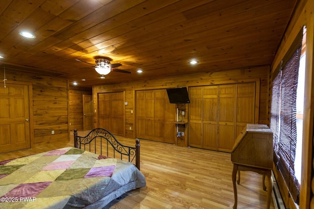 bedroom with light hardwood / wood-style flooring, ceiling fan, wooden walls, and wood ceiling