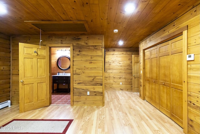 hall with wood walls, wooden ceiling, and light hardwood / wood-style flooring