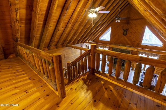 interior space featuring wood-type flooring, lofted ceiling with beams, ceiling fan, and wooden ceiling