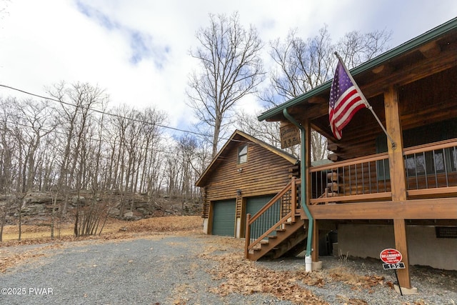 view of property exterior featuring a porch, a garage, and a wooden deck