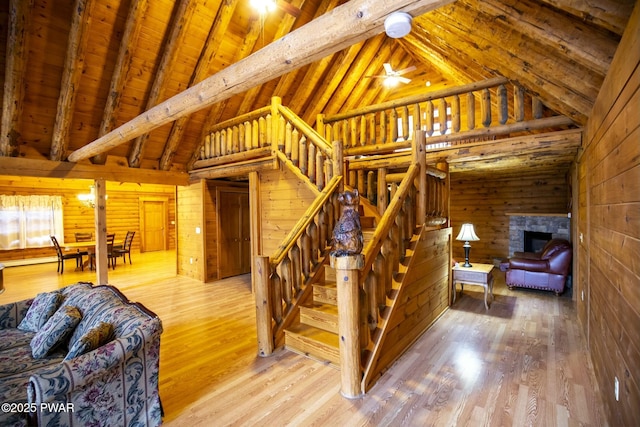 stairs with beam ceiling, ceiling fan, wood ceiling, and wood-type flooring