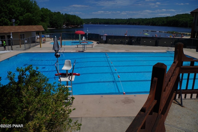 view of swimming pool with a water view and a patio area